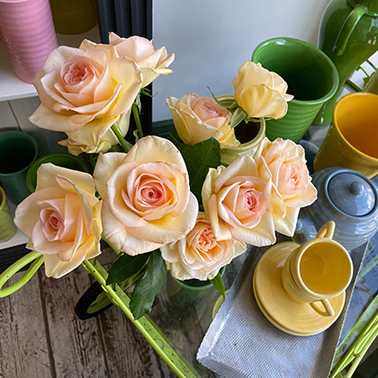 Garden roses and an assortment of Bauer pottery on a florist cart