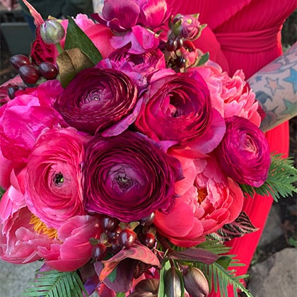 October wedding bouquet in shades of red flowers to match the bride's dress.
