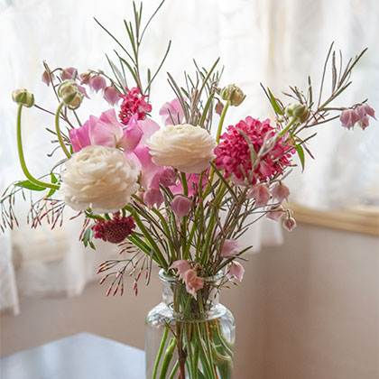 A light and airy Winter flower arrangement of Australian bells, Ranunculus and scabiosa grace this living room.