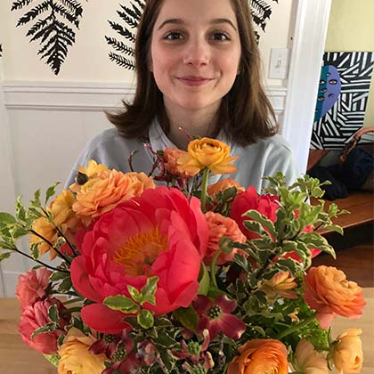 A young recipient expresses joy and happiness upon receiving a Freshly Cut flower arrangement.