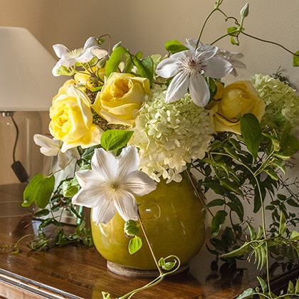 California potter Aletha Soule's chartreuse vase was perfect for this wedding party at home, filled with white clematis, David Austin yellow roses and hydrangeas.
